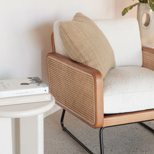 Natuurlijke Rotan Fauteuil in Walnootkleur van dichtbij in een woonkamer samen met een bijzettafeltje van Furnified.ALT